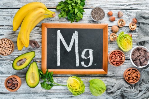 foods-containing-natural-magnesium-mg-chocolate-banana-cocoa-nuts-avocados-broccoli-almonds-top-view-white-wooden-background