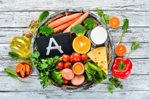 foods-containing-natural-vitamin-broccoli-carrots-milk-cheese-spinach-apricots-parsley-tomatoes-white-wooden-background-top-view-1