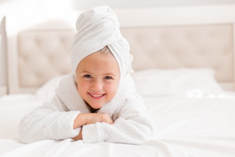 portrait-little-girl-white-bathrobe-with-white-towel-her-head-lying-bed-1